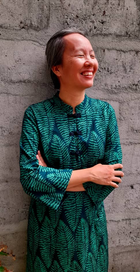 Yikee Adje in a green dress, eyes closed